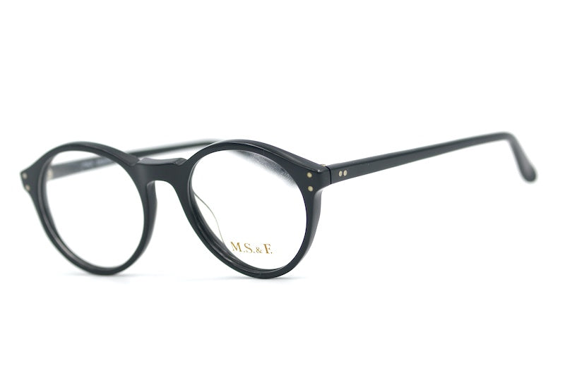 M.S. & F. 40s style round black glasses with rivet detail. 